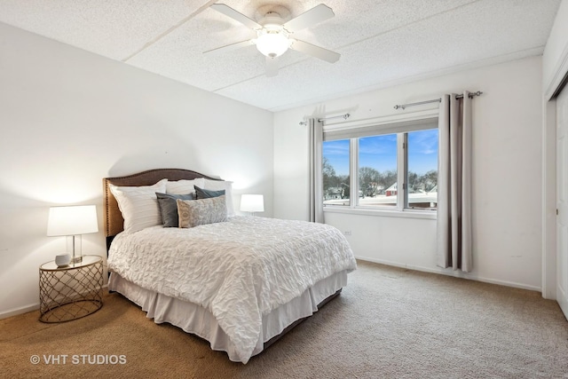 bedroom with ceiling fan, carpet, and a textured ceiling