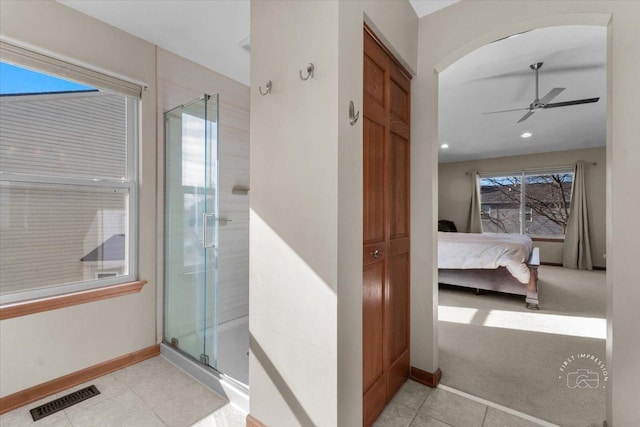 bathroom featuring walk in shower, ceiling fan, and tile patterned floors