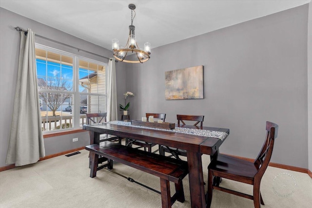 carpeted dining area featuring a chandelier