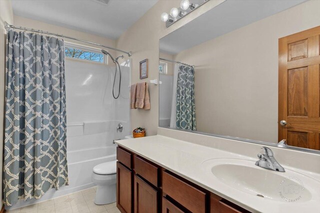 full bathroom featuring shower / bath combination with curtain, vanity, and toilet