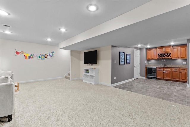 unfurnished living room with light colored carpet, bar area, and beverage cooler