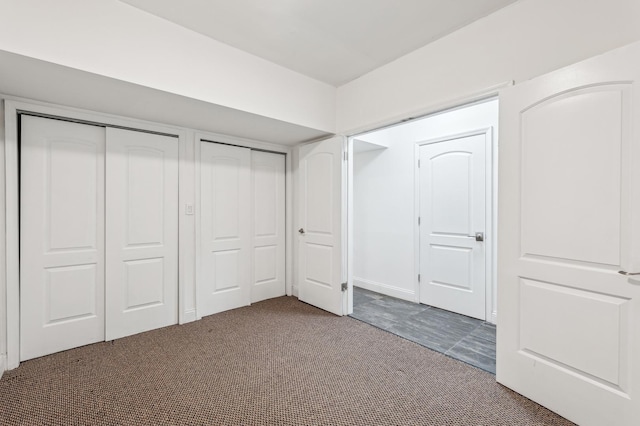 unfurnished bedroom featuring two closets and carpet flooring