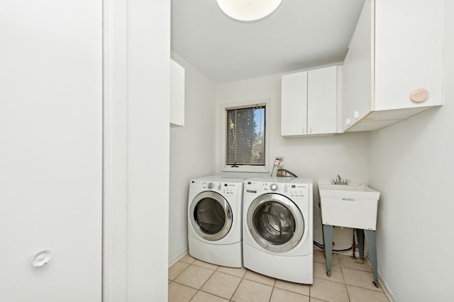 laundry room with cabinets, light tile patterned floors, and separate washer and dryer