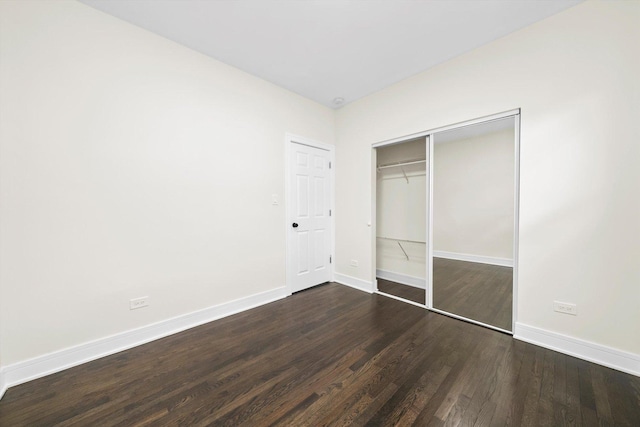 unfurnished bedroom featuring dark hardwood / wood-style flooring and a closet