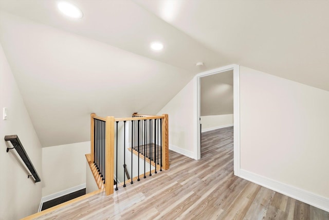 additional living space with light hardwood / wood-style flooring and vaulted ceiling