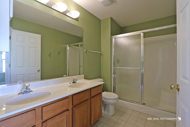 bathroom with vanity, toilet, and a shower with door