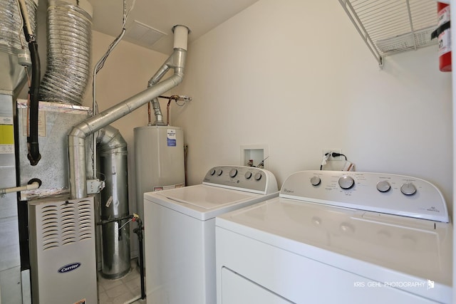 laundry room with water heater, washing machine and clothes dryer, and gas water heater