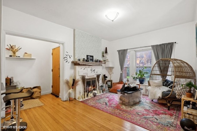 living area with a large fireplace and hardwood / wood-style flooring