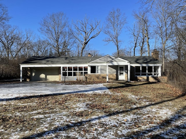 view of front of house with a garage, a sunroom, and a carport