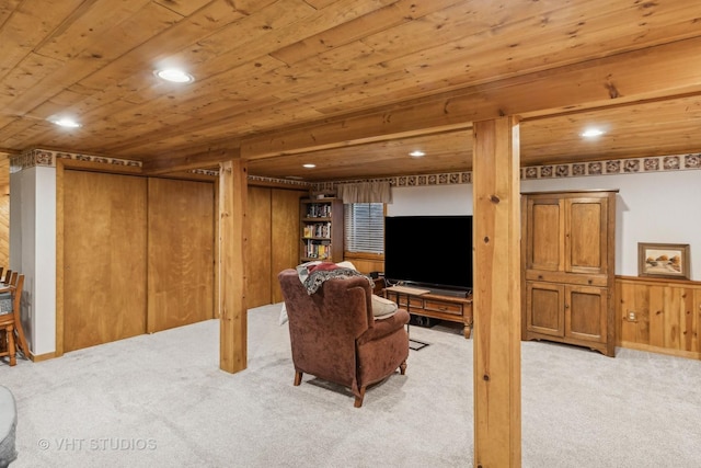 carpeted living room with wood ceiling and wood walls