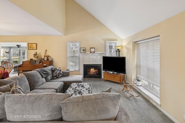 carpeted living room with lofted ceiling, ceiling fan, and a healthy amount of sunlight