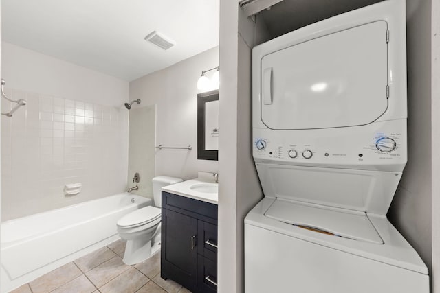 washroom featuring sink, stacked washer / dryer, and light tile patterned flooring