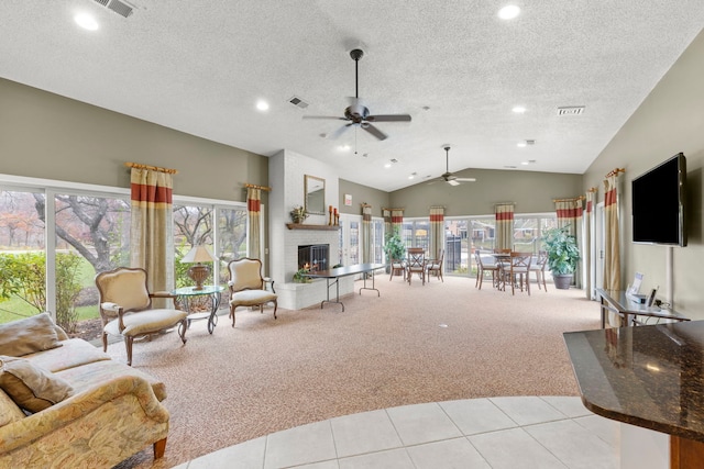 carpeted living room featuring ceiling fan, a wealth of natural light, lofted ceiling, and a textured ceiling