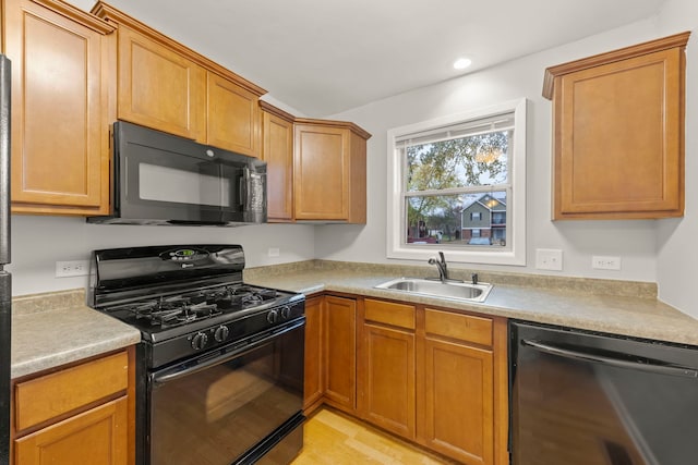 kitchen featuring sink, light wood-type flooring, and black appliances