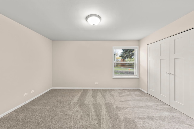 unfurnished bedroom with a closet and light carpet