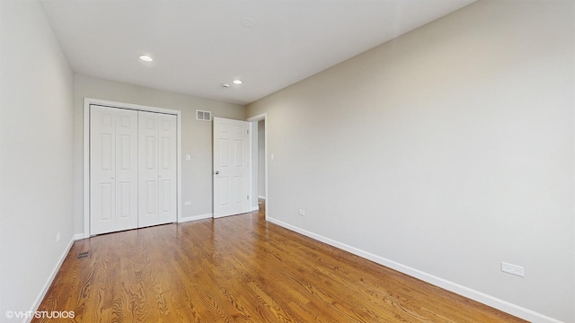 unfurnished bedroom featuring a closet and hardwood / wood-style floors