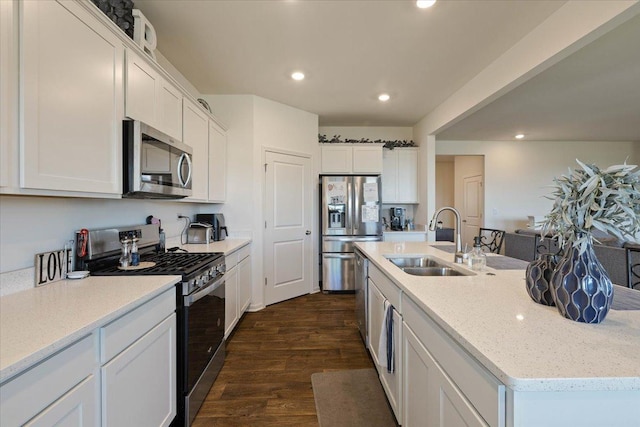 kitchen with an island with sink, dark hardwood / wood-style flooring, white cabinetry, appliances with stainless steel finishes, and sink