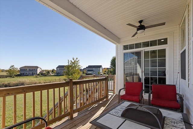 wooden deck with ceiling fan and a yard