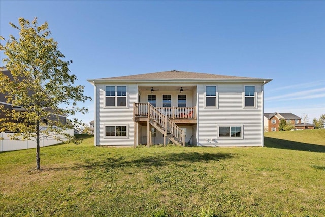 back of house with ceiling fan, a lawn, and a wooden deck