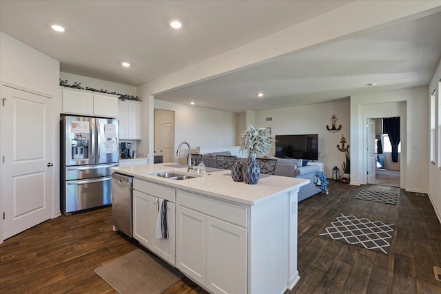 kitchen featuring sink, appliances with stainless steel finishes, white cabinetry, an island with sink, and dark wood-type flooring