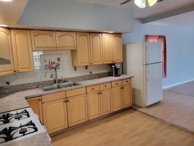 kitchen featuring sink, backsplash, white refrigerator, and light wood-type flooring