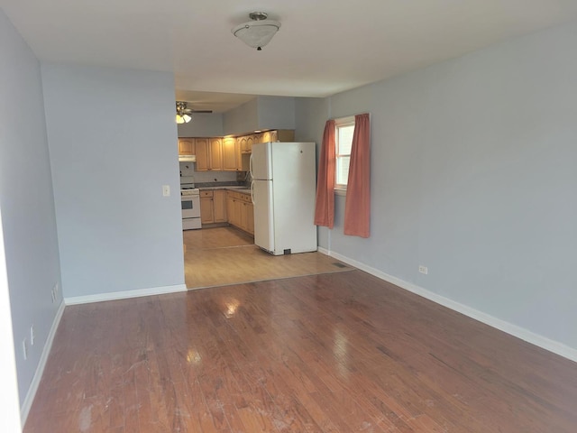 kitchen with light brown cabinetry, white appliances, ceiling fan, and light wood-type flooring