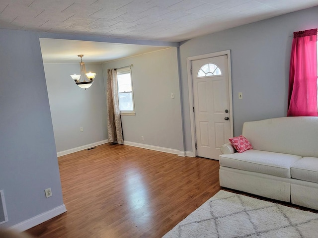 entrance foyer featuring hardwood / wood-style floors and a chandelier