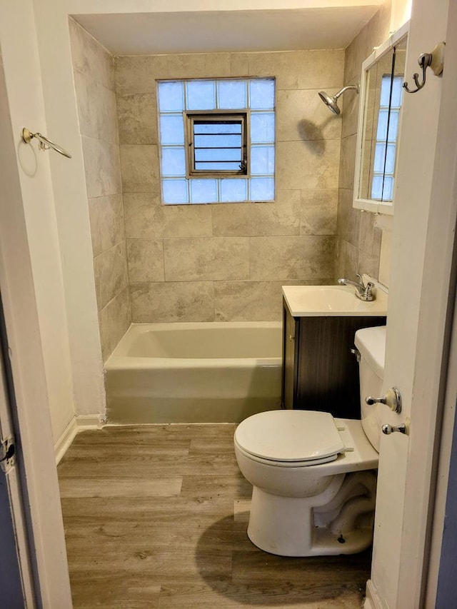 full bathroom featuring toilet, vanity, tiled shower / bath, and hardwood / wood-style floors