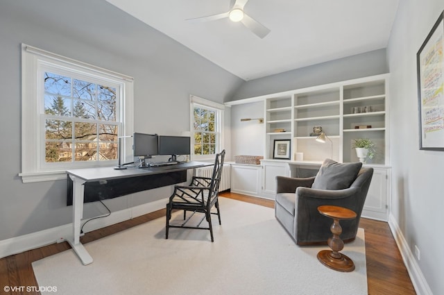 office area with ceiling fan, radiator heating unit, light hardwood / wood-style flooring, and lofted ceiling