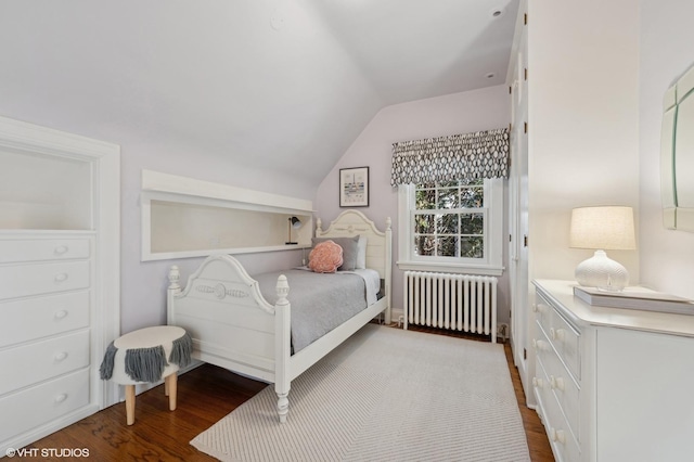 bedroom with wood-type flooring, radiator, and lofted ceiling