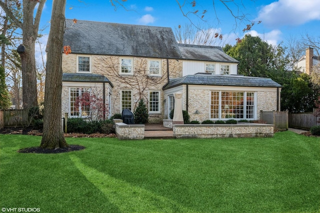 back of house with a patio area and a lawn