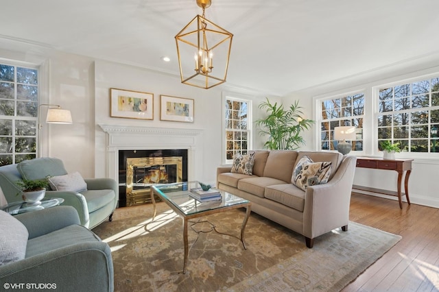 living room with a chandelier, ornamental molding, and hardwood / wood-style flooring