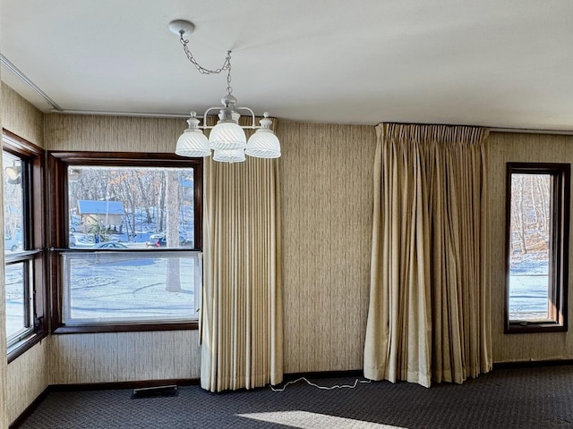 interior space featuring a chandelier and dark colored carpet