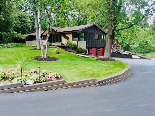 view of front of home with a garage and a front lawn