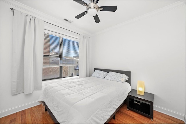 bedroom featuring ceiling fan, wood-type flooring, and crown molding