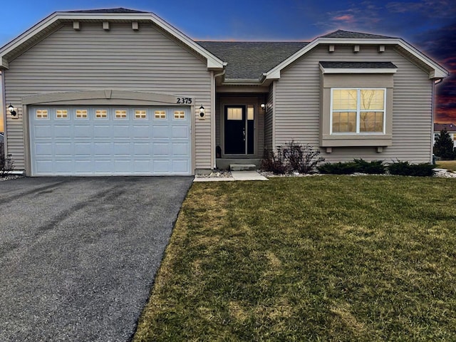 view of front of home featuring a garage and a yard