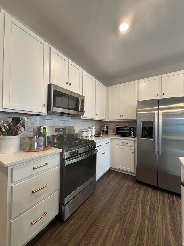 kitchen featuring stainless steel appliances, tasteful backsplash, white cabinets, and dark hardwood / wood-style flooring