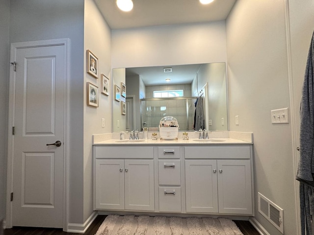 bathroom with vanity, an enclosed shower, and hardwood / wood-style floors