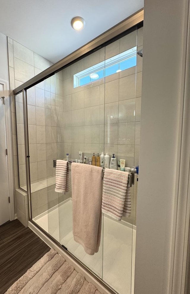 bathroom featuring a shower with door and hardwood / wood-style floors