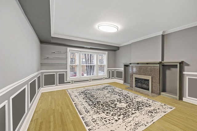 unfurnished living room with crown molding, a fireplace, and wood-type flooring