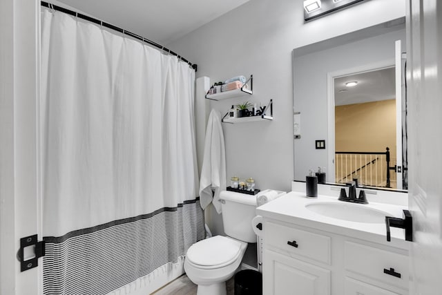 bathroom with toilet, vanity, and curtained shower