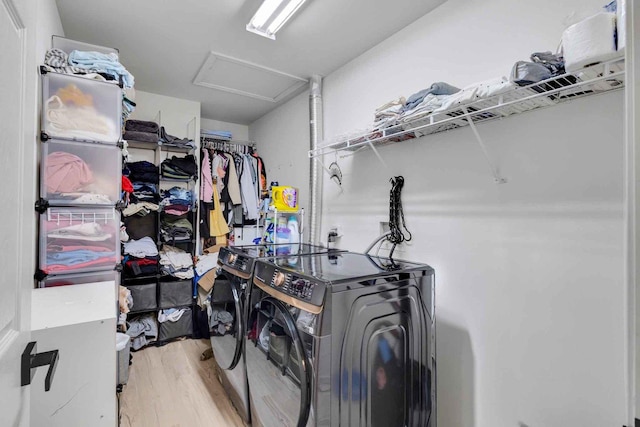 clothes washing area with washer and clothes dryer and light hardwood / wood-style floors