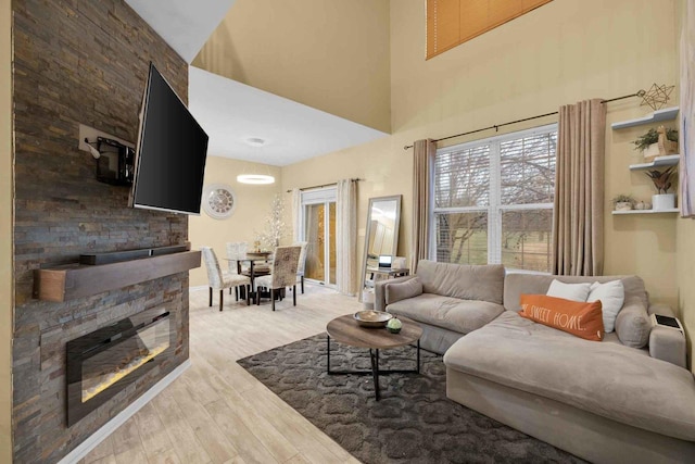 living room featuring light hardwood / wood-style floors and a stone fireplace