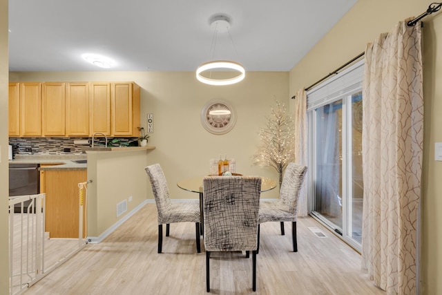 dining area featuring sink and light wood-type flooring