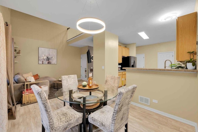 dining room with sink and light hardwood / wood-style flooring