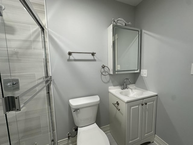 full bathroom with baseboards, toilet, a stall shower, and vanity