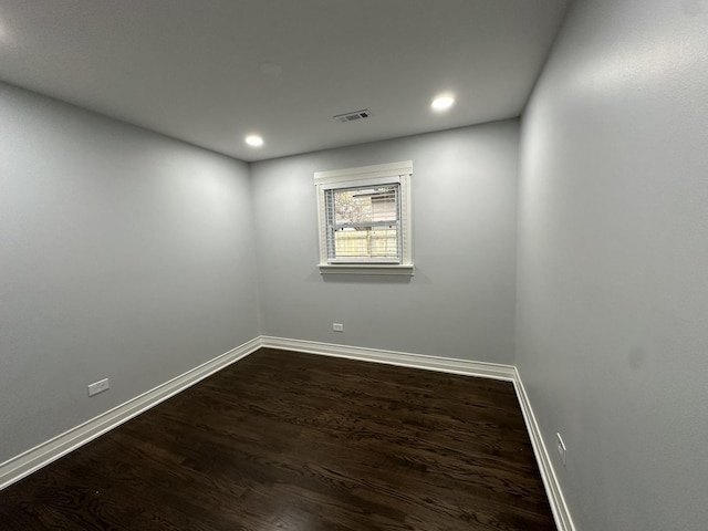 unfurnished room featuring dark wood-type flooring, recessed lighting, baseboards, and visible vents