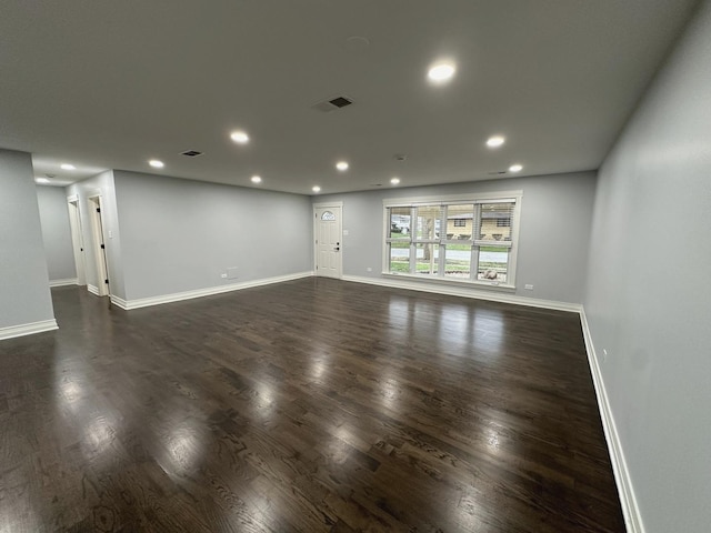 unfurnished room with dark wood finished floors, visible vents, recessed lighting, and baseboards