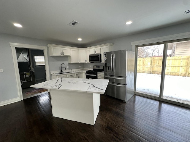 kitchen featuring dark wood-style floors, visible vents, appliances with stainless steel finishes, and a sink