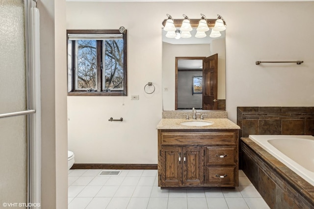 bathroom with toilet, vanity, tile patterned flooring, and tiled tub